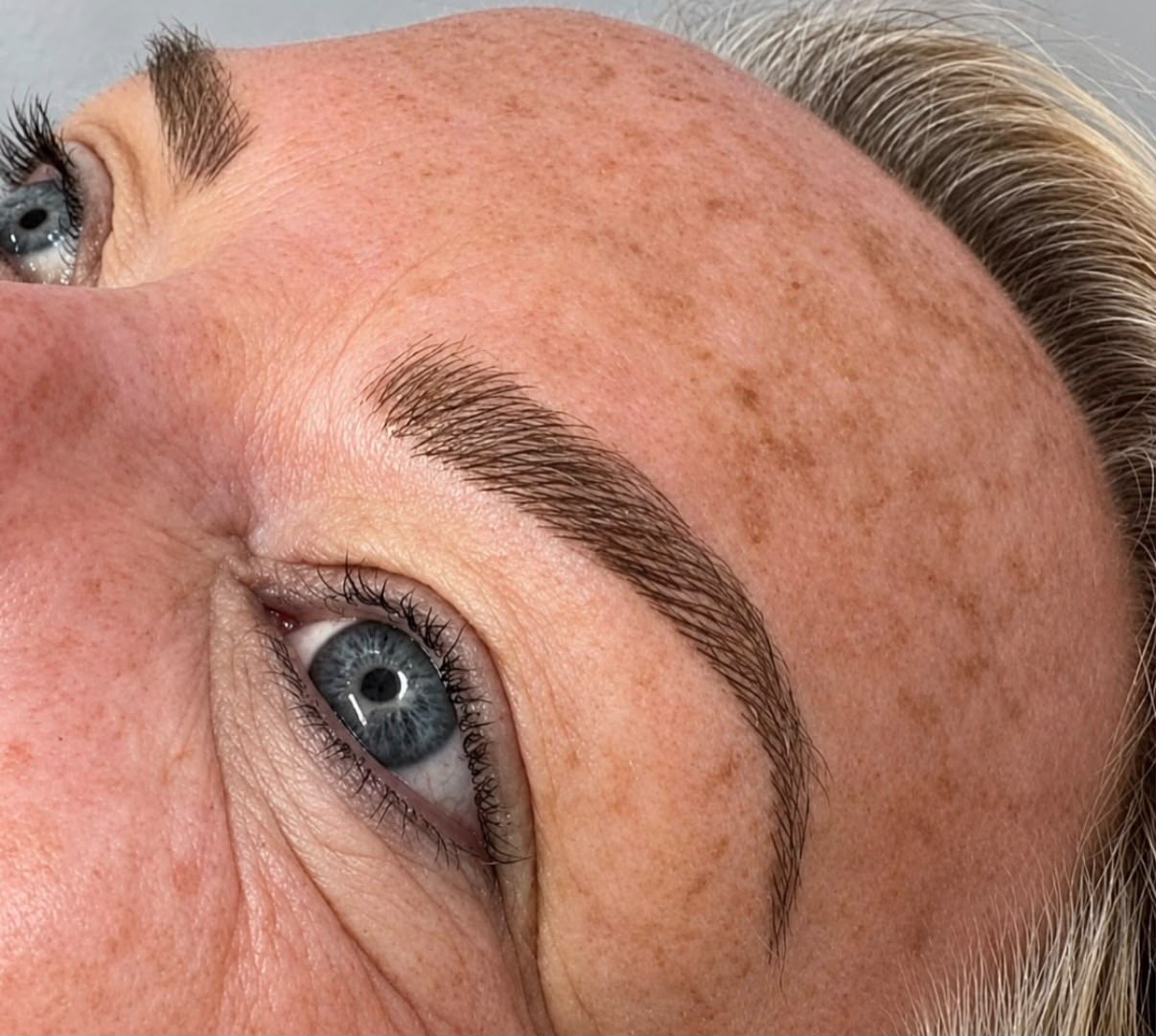 Microblading blended into natural, freckled skin